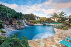 普林斯维尔Club Wyndham Bali Hai Villas的一个带瀑布和蓝色椅子的度假游泳池
