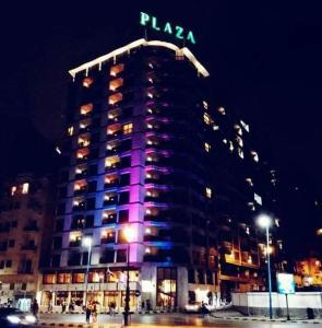 亚历山大亚历山大广场酒店的一座高大的建筑,晚上有紫色的灯光