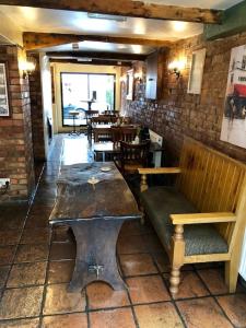 埃文河畔斯特拉特福The Queens Head的餐厅内带长凳和桌子的房间