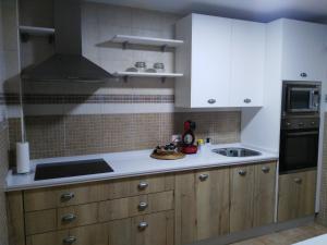 丰特埃里多斯Alojamiento La Fuente的厨房配有白色橱柜和炉灶烤箱。