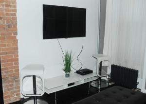 布鲁克林Plush Spacious 1 bedroom apt Williamsburg的一张带两把椅子的白色书桌和墙上的电视
