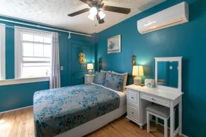 夏洛特顿Prince Street Suites的一间拥有蓝色墙壁的卧室和一张带白色书桌的床