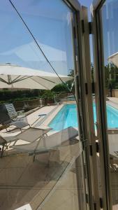 Genolier乐利尔家庭旅馆的透过玻璃窗可欣赏到游泳池的景色