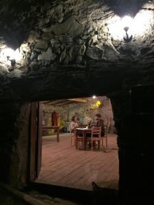 梅斯蒂亚Guest House Keti Margiani Mestia的两个人坐在一个洞穴的桌子上