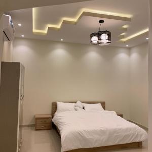塔伊夫Al Taif Villas的卧室配有一张白色大床和吊灯。