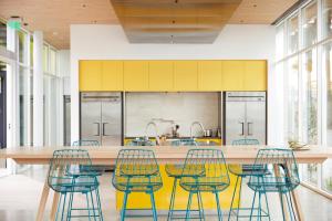 洛杉矶马尤米酒店的厨房配有黄色和蓝色的椅子和桌子