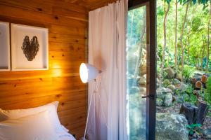 BiscoitosCaparica Azores Ecolodge的一间卧室配有一张床,玻璃门设有窗户