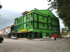 双溪大年Sastria Hotel Sungai Petani的街道边的绿色建筑