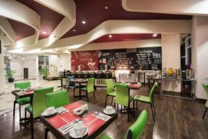 雅加达普鲁特村最爱酒店的一间带绿色桌椅和柜台的餐厅