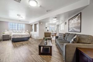 埃尔卡洪Rancho San Diego Inn & Suites的客厅配有沙发和1张床