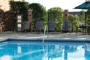 杰克逊维尔杰克逊维尔机场君悦酒店的一个带椅子的游泳池以及一个喷泉