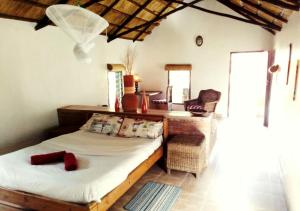 利隆圭Barefoot Lodge and Safaris - Malawi的一间卧室配有一张床、一张桌子和一把椅子