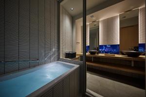 东京ONSEN RYOKAN YUEN SHINJUKU的一间带大浴缸和两个盥洗盆的浴室