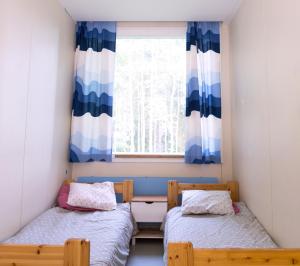SaariharjuNikkilän Elämyskylä的带窗户的客房内的两张床