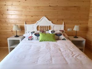 LlantenoSatia Berri的卧室配有白色的木墙床