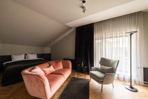 利耶帕亚Maestro Design Hotel的一间卧室配有一张床、一张沙发和一把椅子