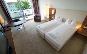 圣珀尔滕圣波罗城市酒店的酒店客房设有一张白色大床和一张书桌