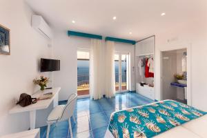 拉维罗Gala Residence Villa Giovanna的一间带一张床和一张书桌的卧室以及一个阳台