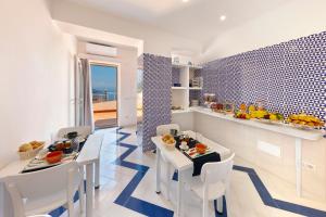 拉维罗Gala Residence Villa Giovanna的厨房以及带桌椅的用餐室。
