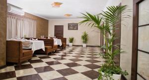 布罗瓦里大运动酒店的一间设有桌椅和植物的餐厅