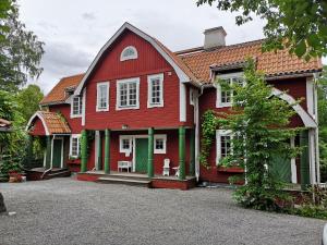 纳卡Stockholm B&B Cottage的一座红色的房子,设有绿门
