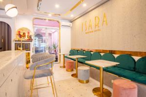 普吉镇Isara Boutique Hotel and Cafe的一间酒吧,房间内设有绿色的椅子和桌子