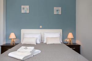 Agia MarinaVilla Serenity的蓝色卧室配有一张大床和两盏灯