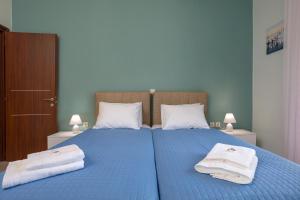 Agia MarinaVilla Serenity的一间卧室配有蓝色的床和毛巾