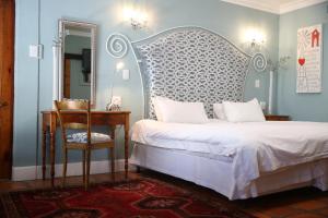 奥茨胡恩De Opstal Country Lodge的一间卧室配有一张床、一把椅子和镜子