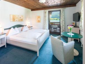 湖滨福煦西温克尔酒店的卧室配有1张床、1张桌子和1把椅子