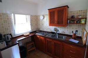 上布雷尼亚Apartamentos Miranda的厨房配有木制橱柜、水槽和窗户。