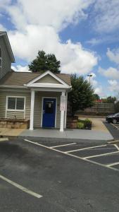 格林维尔InTown Suites Extended Stay Greenville SC -I-85 Mauldin的停车场内有蓝色门的房子