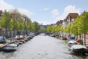 莱顿Tiny Monumental House in Down Town Leiden的城市中一条有船的河流