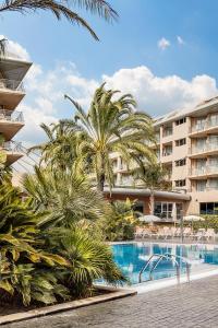 圣苏珊娜AQUA Hotel Onabrava & Spa 4*Sup的一个带游泳池和棕榈树的度假村
