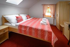 JavorniceVenclův statek的卧室配有红色和白色的床,设有窗户