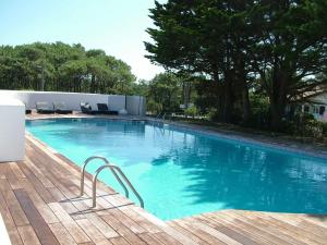 安格雷Villa Clara, Résidence face à l'océan et au golf de Chiberta的一个带木制甲板的大型游泳池