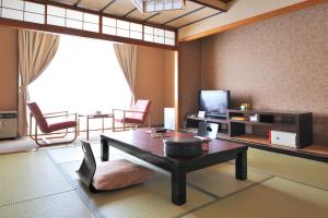 藏王温泉最上高汤七乃汤大平酒店的客厅配有桌子和电视