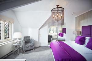 埃格姆Great Fosters - Near Windsor的紫色卧室配有一张床和吊灯