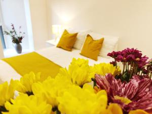 曼彻斯特Ekhaya three的一张带一束黄色和紫色花的床