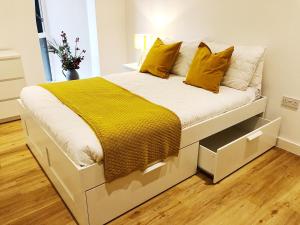 曼彻斯特Ekhaya three的卧室内的一张带黄色枕头的大型白色床