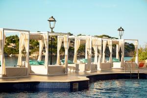 圣蓬萨Sentido Fido Punta del Mar Hotel & Spa - Adults Only的水面上一排白色椅子