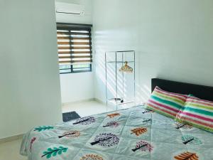 瓜拉雪兰戈Family homestay的一间卧室配有一张带五颜六色被子的床和一扇窗户