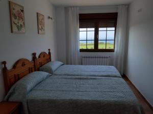 桑提亚纳德玛APARTAMENTOS EL SOLO的一间卧室设有两张床和窗户。