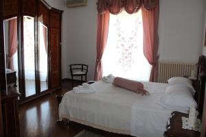 鲁蒂利亚诺DueElle的卧室配有白色的床和窗户。