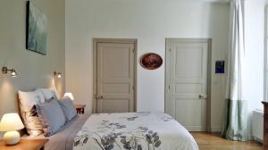 绍雷莱博恩Le Clos des Roseaux的一间卧室设有一张床和两个白色门