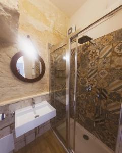 法维尼亚纳Cave Garden rooms的带淋浴、盥洗盆和镜子的浴室