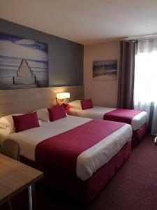 弗雷瑞斯Atoll Hotel restaurant的酒店客房设有两张床和一张桌子。