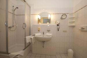 奥斯特巴德·哥伦AKZENT Waldhotel Spa Rügen的白色的浴室设有水槽和淋浴。