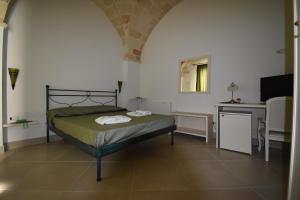 阿韦特拉纳La Gemma del Sud的一间卧室配有一张床、一张书桌和一台电视