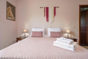 Agia MarinaVilla Serenity的卧室配有带毛巾的大型白色床